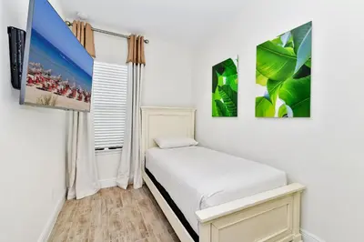 a bedroom with a bed and three pictures on the wall at Sand Delight Near Disney With Margaritaville Resort & Island H20 Waterpark Access - 3152Cs in Orlando
