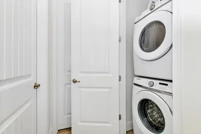 a washer and dryer in a white laundry room at Sand Delight Near Disney With Margaritaville Resort & Island H20 Waterpark Access - 3152Cs in Orlando
