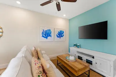 a living room with a white couch and a flat screen tv at Alluring Villa Near Disney With Margaritaville Resort & Island H2O Access - 3057Cs in Orlando