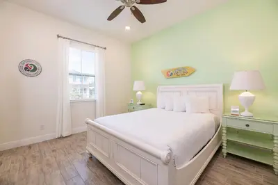 a bedroom with a white bed and a window at Kokomo Cottage Near Disney With Margaritaville Resort & Island H2O Access - 8034Su in Orlando