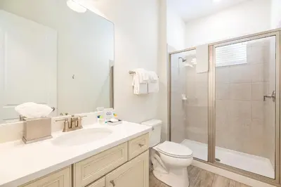 a white bathroom with a toilet and a shower at Kokomo Cottage Near Disney With Margaritaville Resort & Island H2O Access - 8034Su in Orlando