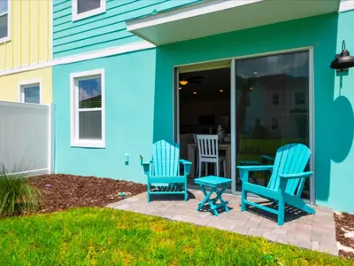 two blue chairs and a table on a patio at Breezy Blue Villa Near Disney With Margaritaville Resort And Island H20 Waterpark Access - 2902Cl in Orlando