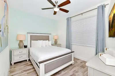 a white bedroom with a bed and a ceiling fan at Sea Blue Villa Near Disney With Margaritaville Resort & Island H20 Access - 3164Cs in Orlando