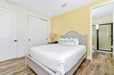 a bedroom with a large bed and a bathroom at Sunshine Cottage With Private Pool Near Disney With Margaritaville Resort & Island H20 Access - 8165Su in Orlando