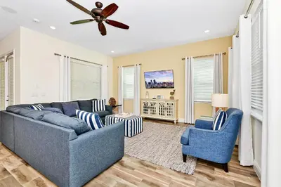 a living room with a blue couch and two chairs at Sunshine Cottage With Private Pool Near Disney With Margaritaville Resort & Island H20 Access - 8165Su in Orlando