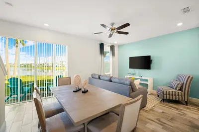 a living room with a table and a couch at Lime Green Villa Near Disney With Margaritaville Resort & Island H20 Waterpark Access - 2965Cs in Orlando
