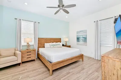 a white bedroom with a bed and a chair at Paradise Cottage With Private Pool Near Disney With Margaritaville Resort & Island H2O Access - 8085Su in Orlando