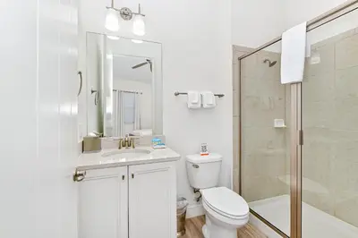 a white bathroom with a toilet and a shower at Paradise Cottage With Private Pool Near Disney With Margaritaville Resort & Island H2O Access - 8085Su in Orlando