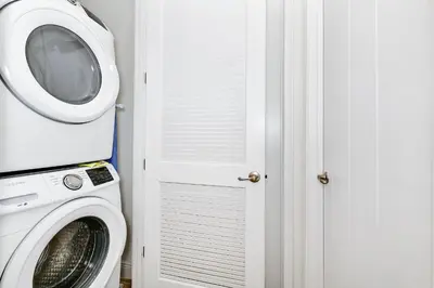 a laundry room with a washing machine and a door at The Shark Tank Cottage With Private Pool Near Disney & Margaritaville Resort & Island H20 Waterpark Access - 3084Ph in Orlando