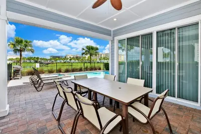 a patio with a table and chairs and a pool at The Shark Tank Cottage With Private Pool Near Disney & Margaritaville Resort & Island H20 Waterpark Access - 3084Ph in Orlando