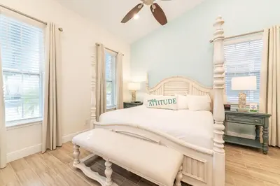 a white bedroom with a white bed and a window at Peachside Cottage Near Disney With Margaritaville Resort & Island H2O Access - 8037Dr in Orlando