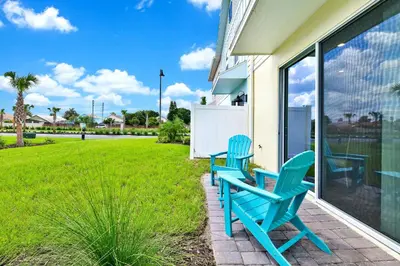 two blue chairs sitting on the porch of a house at Sunny Villa Near Disney With Margaritaville Resort & Island H20 Access - 8111Cp in Orlando