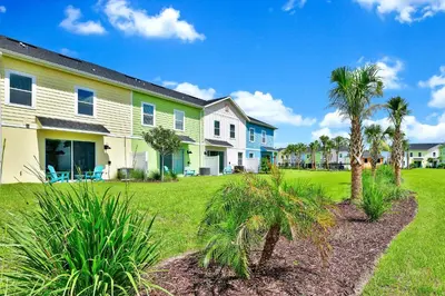 a row of houses with palm trees in a yard at Sunny Villa Near Disney With Margaritaville Resort & Island H20 Access - 8111Cp in Orlando