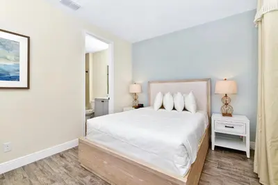 a white bedroom with a bed and two lamps at Sunny Villa Near Disney With Margaritaville Resort & Island H20 Access - 8111Cp in Orlando