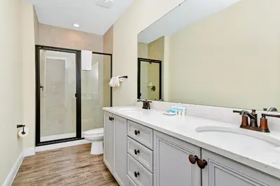 a bathroom with a sink and a toilet and a mirror at Breezy Blue Villa Near Disney With Margaritaville Resort & Island H20 Waterpark Access - 2952Cs in Orlando