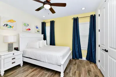 a bedroom with a white bed and a ceiling fan at Sun Filled Villa Near Disney With Margaritaville Resort & Island H20 Access - 8119Cp in Orlando
