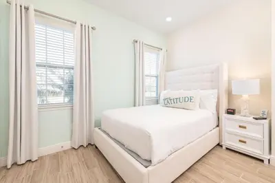 a white bedroom with a white bed and a window at Ocean Blue Cove Cottage Near Disney With Margaritaville Resort & Island H2O Access - 8020Ls in Orlando