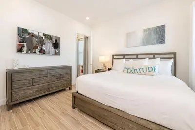 a bedroom with a large white bed with a wooden dresser at Ocean Blue Cove Cottage Near Disney With Margaritaville Resort & Island H2O Access - 8020Ls in Orlando