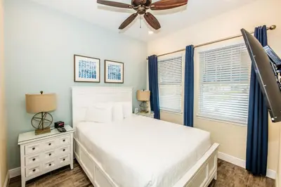 a bedroom with a white bed and a ceiling fan at Flip Flops And Tank Tops Cottage With Private Pool Near Disney With Margaritaville Resort & Island H2O Access - 8098Kd in Orlando
