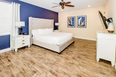 a bedroom with a white bed and a ceiling fan at Flip Flops And Tank Tops Cottage With Private Pool Near Disney With Margaritaville Resort & Island H2O Access - 8098Kd in Orlando