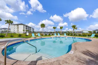 a large swimming pool with chairs and palm trees at Colorful Villa Near Disney With Margaritaville Resort & Island H20 Waterpark Access - 3128Cs in Orlando