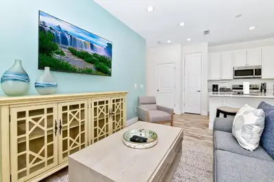 a living room with a couch and a tv on a wall at Colorful Villa Near Disney With Margaritaville Resort & Island H20 Waterpark Access - 3128Cs in Orlando