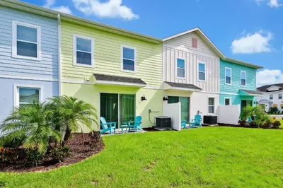 a house with a lawn in front of it at Colorful Villa Near Disney With Margaritaville Resort & Island H20 Waterpark Access - 3128Cs in Orlando