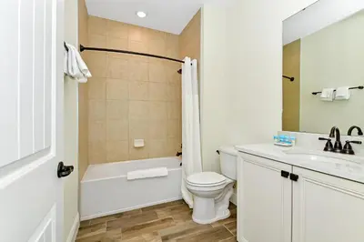 a bathroom with a tub and a toilet and a sink at Orange Oasis Villa Near Disney With Margaritaville Resort & Island H20 Waterpark Access - 3097Cs in Orlando