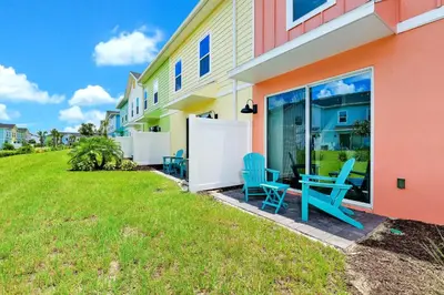 a house with blue chairs outside of it at Colorful Villa Near Disney With Margaritaville Resort & Island H20 Access - 8195Cp in Kissimmee