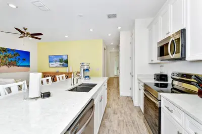 a kitchen with white cabinets and a counter top at Lime Green Villa Near Disney With Margaritaville Resort & Island H20 Waterpark Access - 2972Or in Orlando