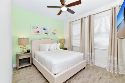 a bedroom with a white bed and a ceiling fan at Pink Villa Near Disney With Margaritaville Resort & Island H20 Access - 8163Cp in Orlando