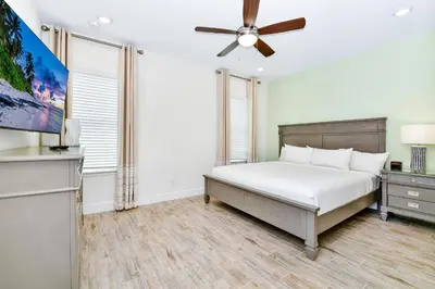 a bedroom with a bed and a ceiling fan at Pink Villa Near Disney With Margaritaville Resort & Island H20 Access - 8163Cp in Orlando