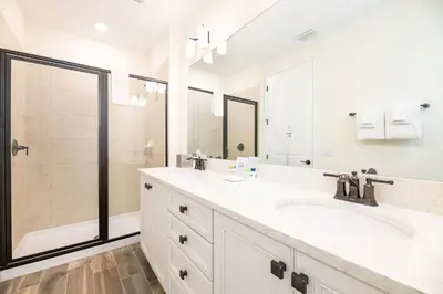 a white bathroom with two sinks and a shower at Sunkissed Cottage With Private Pool Near Disney With Margaritaville Resort & Island H2O Access - 8024Kd in Orlando