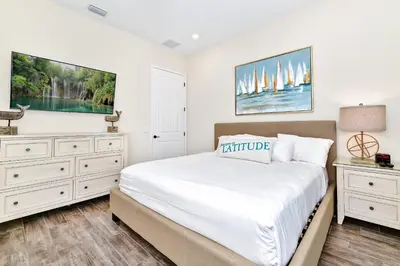 a white bedroom with a bed and two dressers at Sunny Cottage With Private Pool Near Disney With Margaritaville Resort & Island H2O Access - 8021Kd in Orlando