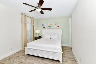 a white bedroom with a white bed and a ceiling fan at Bright Villa Near Disney With Margaritaville Resort & Island H20 Access - 8191Cp in Orlando