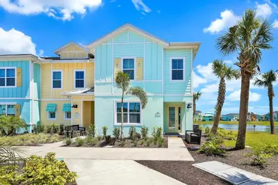 a house with palm trees in front of it at Beautiful Waterfront Villa Near Disney With Margaritaville Resort & Island H20 Waterpark Access - 3017Cs in Orlando