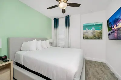 a white bedroom with a white bed and a ceiling fan at Beautiful Waterfront Villa Near Disney With Margaritaville Resort & Island H20 Waterpark Access - 3017Cs in Orlando