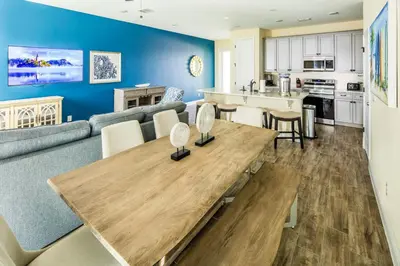 a kitchen and living room with a wooden table at Breezy Villa Near Disney With Margaritaville Resort & Island H20 Access - 8177Su in Orlando