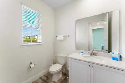 a white bathroom with a toilet and a sink at Bright And Cozy Villa Near Disney With Margaritaville Resort & Island H2O Access - 3053Cs in Orlando