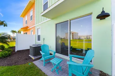 two blue chairs sitting on a patio next to a house at Bright And Cozy Villa Near Disney With Margaritaville Resort & Island H2O Access - 3053Cs in Orlando