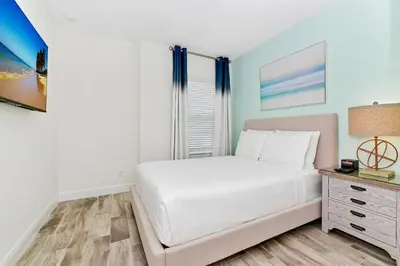 a bedroom with a white bed and a desk at Lovely Villa Near Disney With Margaritaville Resort & Island H20 Waterpark Access - 2956Or in Orlando