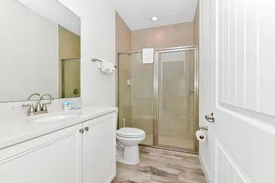 a white bathroom with a toilet and a shower at Lovely Villa Near Disney With Margaritaville Resort & Island H20 Waterpark Access - 2956Or in Orlando