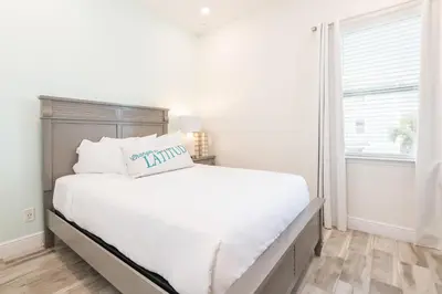 a white bedroom with a large bed and a window at Cozy Cottage With Private Pool Near Disney With Margaritaville Resort & Island H2O Access - 8041Kd in Orlando