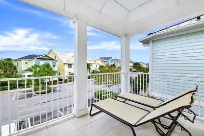 a white porch with a chair on a balcony at Lively Cottage With Hot Tub Near Disney With Margaritaville Resort & Island H2O Access - 8030Su in Orlando