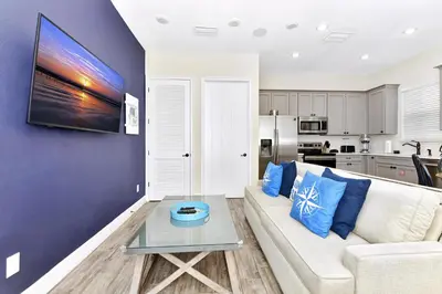 a living room with a couch and a table at Lively Cottage With Hot Tub Near Disney With Margaritaville Resort & Island H2O Access - 8030Su in Orlando