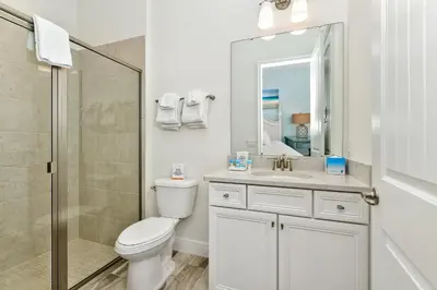 a bathroom with a toilet and a sink and a shower at Beautiful Waterfront Cottage With Private Pool Near Disney With Margaritaville Resort & Island H2O Access - 3024Ph in Orlando