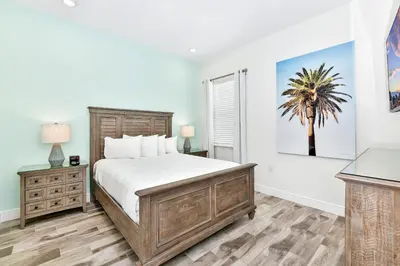 a bedroom with a bed and a palm tree on the wall at Beautiful Waterfront Cottage With Private Pool Near Disney With Margaritaville Resort & Island H2O Access - 3024Ph in Orlando
