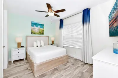 a bedroom with a bed and a ceiling fan at Glimmering Blue Villa Near Disney With Margaritaville Resort & Island H20 Waterpark Access - 3016Cs in Orlando