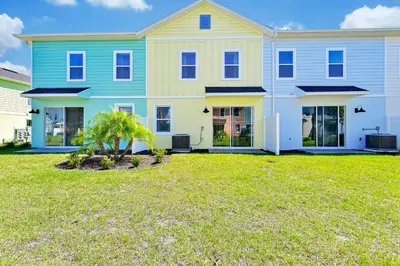 a large blue and yellow house with a yard at Relaxing Villa Near Disney With Margaritaville Resort & Island H20 Waterpark Access - 2992Cs in Orlando