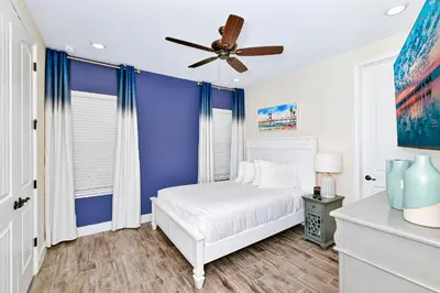 a blue bedroom with a white bed and a ceiling fan at Relaxing Villa Near Disney With Margaritaville Resort & Island H20 Waterpark Access - 2992Cs in Orlando